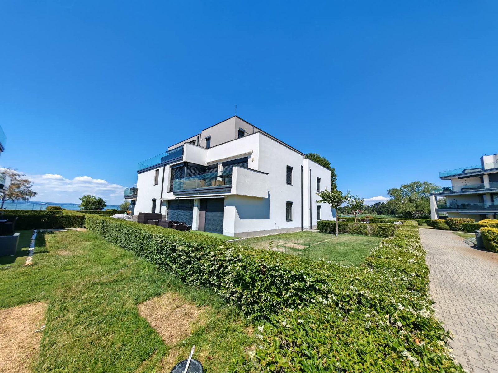 Siófok Arany Apartmanok felújított homlokzata Balaton-parti környezetben